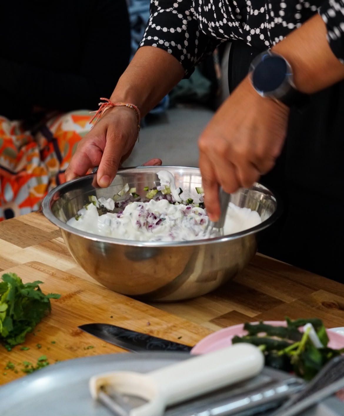 Mãos a misturar ingredientes numa taça de inox