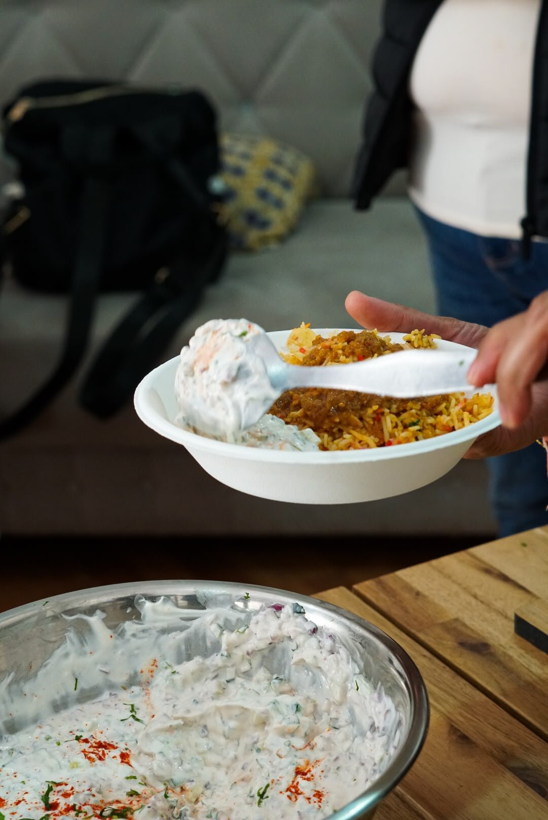 Colherada de arroz e raita a ser servida